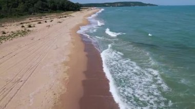 Karadeniz kıyısındaki vahşi Bulgar sahillerinin hava görüntüleri. Saf kum, turkuaz su, yumuşak dalgalar ve güneşli bir yaz gününde yukarıdan yakalanan el değmemiş doğa..