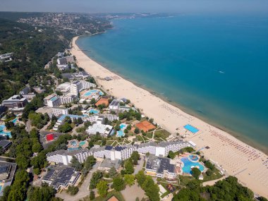Bulgaristan 'ın Karadeniz kıyısındaki Albena tatil beldesinin havadan manzarası. Yazın geniş kumlu plaj, şemsiye, otel ve ormanlı tepeler..