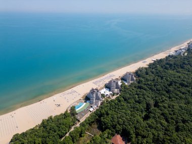 Bulgaristan 'ın Karadeniz kıyısındaki Albena tatil beldesinin havadan manzarası. Yazın geniş kumlu plaj, şemsiye, otel ve ormanlı tepeler..