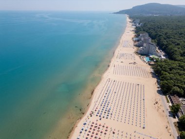Bulgaristan 'ın Karadeniz kıyısındaki Albena tatil beldesinin havadan manzarası. Yazın geniş kumlu plaj, şemsiye, otel ve ormanlı tepeler..