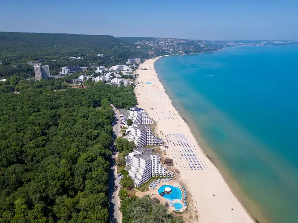 Bulgaristan 'ın Karadeniz kıyısındaki Albena tatil beldesinin havadan manzarası. Yazın geniş kumlu plaj, şemsiye, otel ve ormanlı tepeler..