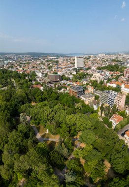 Bulgaristan 'ın Varna kentinin havadan panoramik manzarası, açık mavi bir gökyüzünün altında kırmızı çatılar, yeşil parklar ve Karadeniz' i gösteriyor..