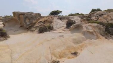 Kuru çalılar ve açık bir gökyüzünün altındaki tepelerle kayalık ve engebeli arazide koşan hızlı yolun ilk şahıs görüntüsü. Vahşi Akdeniz doğasında yoğun açık hava aktivitesi.