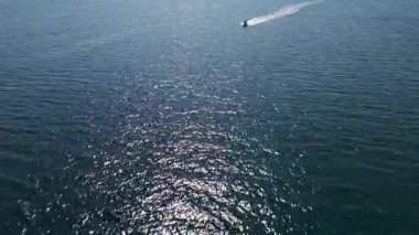 Pırıl pırıl mavi denizde süzülen bir sürat teknesinin havadan görünüşü ardında beyaz bir iz bırakıyor. Açık denizde hareket, özgürlük ve yaz macerası yakalar..