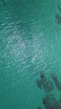 Kristal berraklığında turkuaz deniz suyunun görünür dokuları ve hafif dalgalanmalarla yakın çekim görüntüsü. Tasarım, seyahat ve yaz temalı içerik için mükemmel doğal arkaplan.