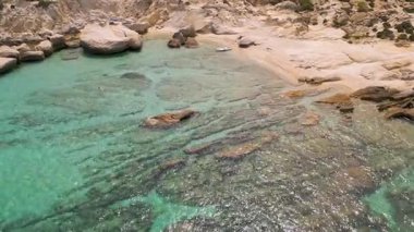 Turkuaz suları ve yoğun ormanı olan kayalık bir Akdeniz sahil şeridinin havadan çekilmiş videosu. İdilik bozulmamış manzara doğa, seyahat ve yaz temalı içerik için mükemmel..
