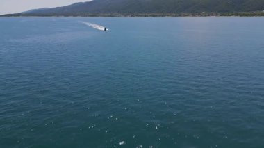 Pırıl pırıl mavi denizde süzülen bir sürat teknesinin havadan görünüşü ardında beyaz bir iz bırakıyor. Açık denizde hareket, özgürlük ve yaz macerası yakalar..