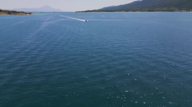 Pırıl pırıl mavi denizde süzülen bir sürat teknesinin havadan görünüşü ardında beyaz bir iz bırakıyor. Açık denizde hareket, özgürlük ve yaz macerası yakalar..