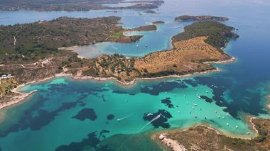 Engebeli kıyı şeridi ve zeytinlikleriyle çevrili, büyüleyici bir turkuaz hangarın havadan görünüşü. Berrak suları ve Akdeniz manzaralı sakin yaz manzarası.