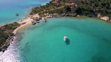 Engebeli kıyı şeridi ve zeytinlikleriyle çevrili, büyüleyici bir turkuaz hangarın havadan görünüşü. Berrak suları ve Akdeniz manzaralı sakin yaz manzarası.