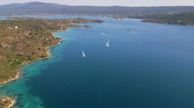 Açık denizdeki açık deniz balık çiftliği kafeslerinin ve platformların havadan görüntüsü. Modern su kültürü yapıları berrak gökyüzünün altında derin mavi sularda yüzerler..