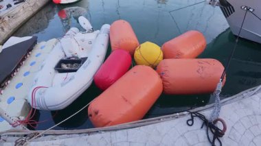 Rıhtımın yakınındaki suda yüzen renkli şişme bot tamponları marinadaki gemileri koruyor. Deniz güvenlik ekipmanlarının yakın görüntüsü.
