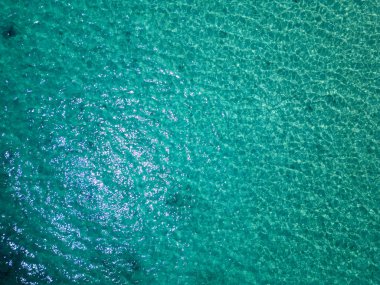 Suyun altındaki kayaların berrak sulardan görülebildiği ışıldayan turkuaz deniz manzarası. Yunanistan 'da sakin bir yaz gününde güneş ışığını yansıtan huzurlu yüzey.