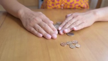 Ahşap bir masada Bulgar Lev paralarını sayan ellerin yakın çekimi. Para, tasarruf, finans, bütçe, ekonomi, yatırım, bankacılık ve ev giderleri kavramı.