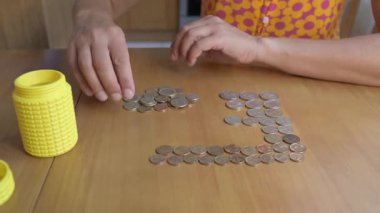 Ahşap bir masada Bulgar Lev paralarını sayan ellerin yakın çekimi. Para, tasarruf, finans, bütçe, ekonomi, yatırım, bankacılık ve ev giderleri kavramı.