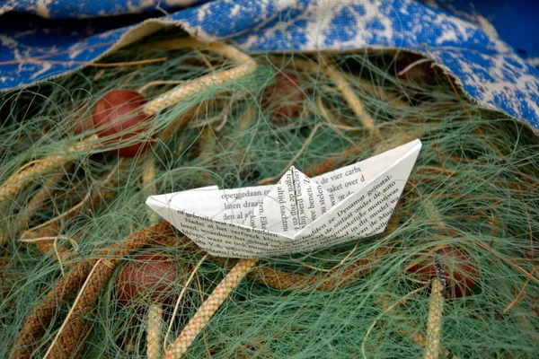 Yeşil balıkçı ağı ve kağıt tekne. Seyahat ve macera kavramı