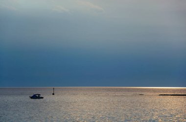Sakin denizde tekne ve gün batımı. Mavi Adriyatik deniz manzarası