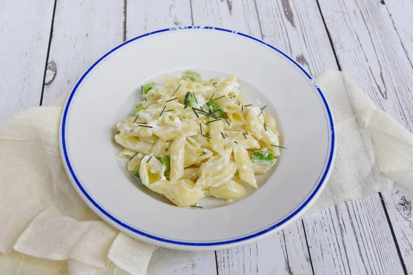 Stock image Plate of pasta with cream cheese and herbs. Cheese sauce pasta served on wooden table