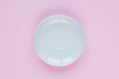 Beyaz plaka, düz yatış. Pembe arka planda boş tabak