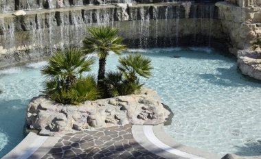 Şelale ve palmiyeli açık yüzme havuzu, tatil beldesi, Hvar, Hırvatistan