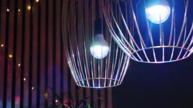 Ev rengarenk ışık diskosu. Lambaların içinde dönen ışık, lambaların içinde ve ahşap çıtada yansıyan bir parti havası yaratıyor. Yüksek kalite 4k görüntü