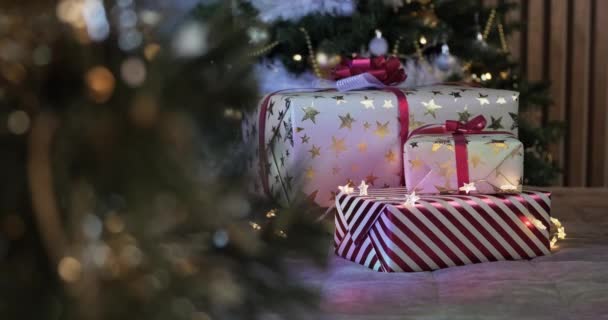 背景にクリスマスツリーとガーランドの光の下でクリスマスや新年の白 赤の贈り物 高品質4K映像 — ストック動画