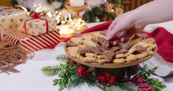 用自制饼干和圣诞礼物装饰桌子 一个女人的手把饼干放在木制盘子上 装饰着节日的餐桌 高质量的4K镜头 — 图库视频影像