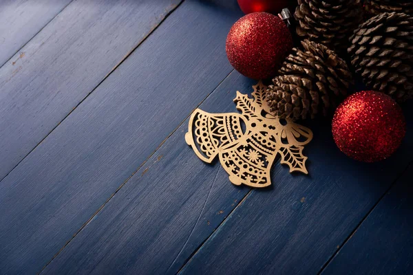 ヴィンテージブルーの木の背景にクリスマスの装飾のための松のコーンと赤いクリスマスボール テキストのスペースをコピー — ストック写真