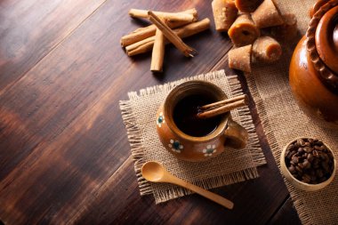 Orijinal ev yapımı Meksika kahvesi (cafe de olla) geleneksel el yapımı kil kupada (Jarrito de barro) rustik ahşap masa üzerinde servis edilir..
