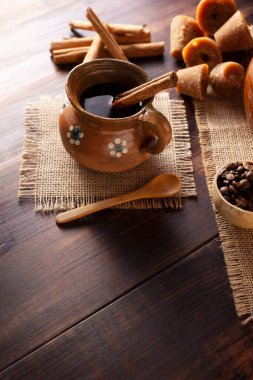 Orijinal ev yapımı Meksika kahvesi (cafe de olla) geleneksel el yapımı kil kupada (Jarrito de barro) rustik ahşap masa üzerinde servis edilir..