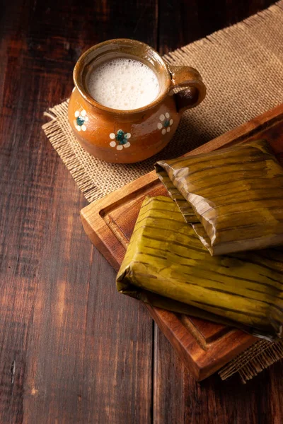 stock image Oaxacan Tamales and Atole. Prehispanic dish typical of Mexico and some Latin American countries. Corn dough wrapped in banana leaves. The tamales are steamed. 