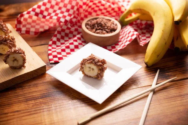 Banana sushi sweet rolls with caramel, peanut butter and chocolate puffed rice. Funny and easy homemade snack for kids and adults.