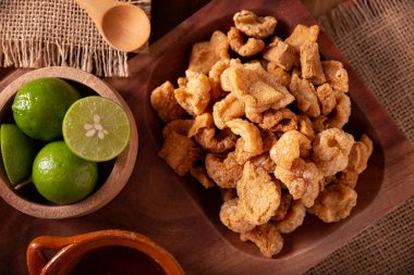 Chicharronelar. Kızarmış domuz derisi, kızarmış domuz derisi, geleneksel Meksika malzemesi ya da limon suyu ve kırmızı acı biber sosuyla servis edilen aperatif..