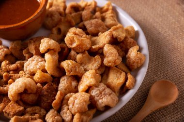 Chicharronelar. Kızarmış domuz derisi, kızarmış domuz derisi, geleneksel Meksika malzemesi ya da limon suyu ve kırmızı acı biber sosuyla servis edilen aperatif..