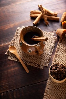 Orijinal ev yapımı Meksika kahvesi (cafe de olla) geleneksel el yapımı kil kupada (Jarrito de barro) rustik ahşap masa üzerinde servis edilir..