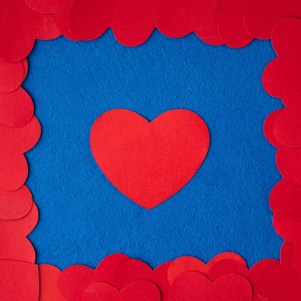 Red paper hearts frame on blue textured background with copy space. Love Concept image. Valentine\'s day, mother\'s day, birthday greeting cards, invitation