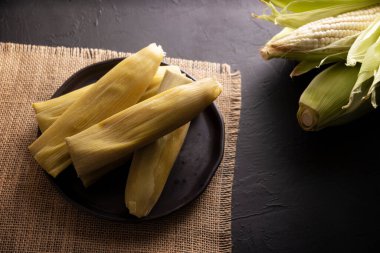 Tamales de Elote, diğer adıyla Uchepos. Tipik Meksika yemeği. Yeşil salsa ile servis edilebilir ve yanında ekşi krema ya da karamel kaplı bir tatlı olarak servis edilebilir.