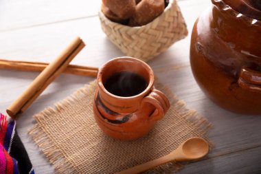 Cafe de Olla 'da. Geleneksel Meksika kahvesi ve temel bileşenleri olan kahve, tarçın ve piloncillo, kırsal ahşap bir yüzey üzerinde 