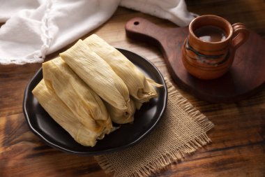 Tamale. Meksika ve bazı Latin Amerika ülkelerinin tipik antipatik yemekleri. Mısır yaprağına sarılmış mısır hamuru. Tamaleler buğulandı.. 