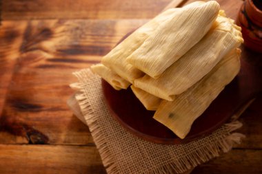 Tamale. Meksika ve bazı Latin Amerika ülkelerinin tipik antipatik yemekleri. Mısır yaprağına sarılmış mısır hamuru. Tamaleler buğulandı.. 