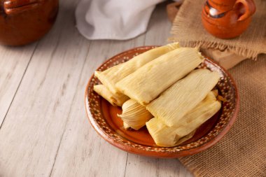 Tamale. Meksika ve bazı Latin Amerika ülkelerinin tipik antipatik yemekleri. Mısır yaprağına sarılmış mısır hamuru. Tamaleler buğulandı.. 