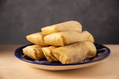 Tamale. Meksika ve bazı Latin Amerika ülkelerinin tipik antipatik yemekleri. Mısır yaprağına sarılmış mısır hamuru. Tamaleler buğulandı.. 