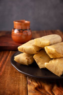 Tamale. Meksika ve bazı Latin Amerika ülkelerinin tipik antipatik yemekleri. Mısır yaprağına sarılmış mısır hamuru. Tamaleler buğulandı.. 