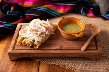 Tacos Dorados. Flautas olarak da bilinen Meksika yemeği, dolgulu mısır tortillasından oluşur, yaygın olarak tavuk veya sığır eti veya patates gibi vejetaryen seçenekleri içerir..