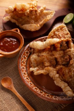 Chicharron. Kızarmış domuz derisi, havalanmış ve kızarmış domuz derisi, geleneksel Meksika malzemesi ya da limon suyu ve kırmızı acı sosla servis edilen aperatif.. 