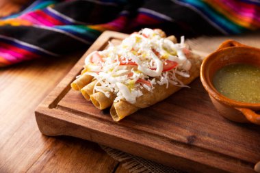 Tacos Dorados. Flautas olarak da bilinen Meksika yemeği, dolgulu mısır tortillasından oluşur, yaygın olarak tavuk veya sığır eti veya patates gibi vejetaryen seçenekleri içerir..