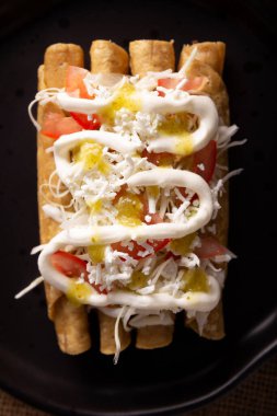 Tacos Dorados. Flautas olarak da bilinen Meksika yemeği, dolgulu mısır tortillasından oluşur, yaygın olarak tavuk veya sığır eti veya patates gibi vejetaryen seçenekleri içerir..