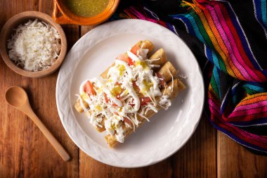 Tacos Dorados. Flautas olarak da bilinen Meksika yemeği, dolgulu mısır tortillasından oluşur, yaygın olarak tavuk veya sığır eti veya patates gibi vejetaryen seçenekleri içerir..