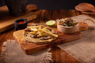 Beef steak taco with french fries. Very popular taco in Mexico called Taco de Bistec or Carne Asada, homemade roast beef served on a corn tortilla. Mexican street food. clipart
