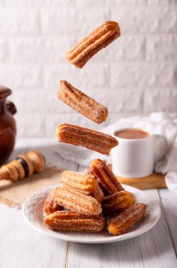 Düşen Churros. Kızarmış buğday unu hamuru, İspanya, Meksika ve diğer ülkelerde kahvaltıda yemek ya da sıcak çikolata eşliğinde yemek gelenektir..